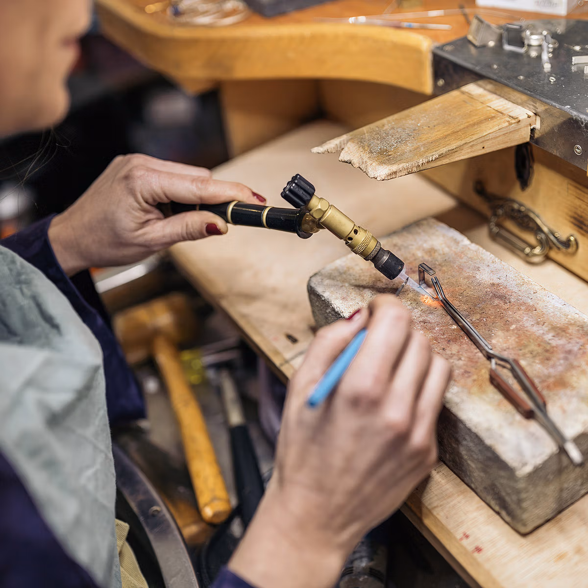 Dans l'atelier du bijoutier, la flamme façonne l'argent Dans l'atelier du bijoutier, la flamme façonne l'argent
