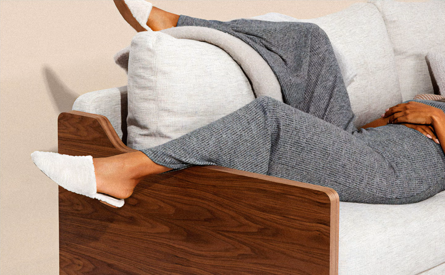 Canapé en lin beige avec tissus performance déhoussable et accoudoirs en noyer sculpté, personne détendue avec plaid gris illustrant la liberté d'usage quotidien qu'offrent les textiles techniques nouvelle génération pour un salon sans anxiété. Canapé en lin beige avec tissus performance déhoussable et accoudoirs en noyer sculpté, personne détendue avec plaid gris illustrant la liberté d'usage quotidien qu'offrent les textiles techniques nouvelle génération pour un salon sans anxiété.