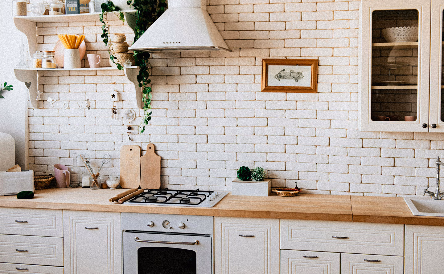 Cuisine scandinave avec mur en briques blanches apparentes, étagères ouvertes contenant bocaux et ustensiles, plan de travail bois clair et plaque de cuisson intégrée illustrant l'organisation fonctionnelle du quotidien Cuisine scandinave avec mur en briques blanches apparentes, étagères ouvertes contenant bocaux et ustensiles, plan de travail bois clair et plaque de cuisson intégrée illustrant l'organisation fonctionnelle du quotidien