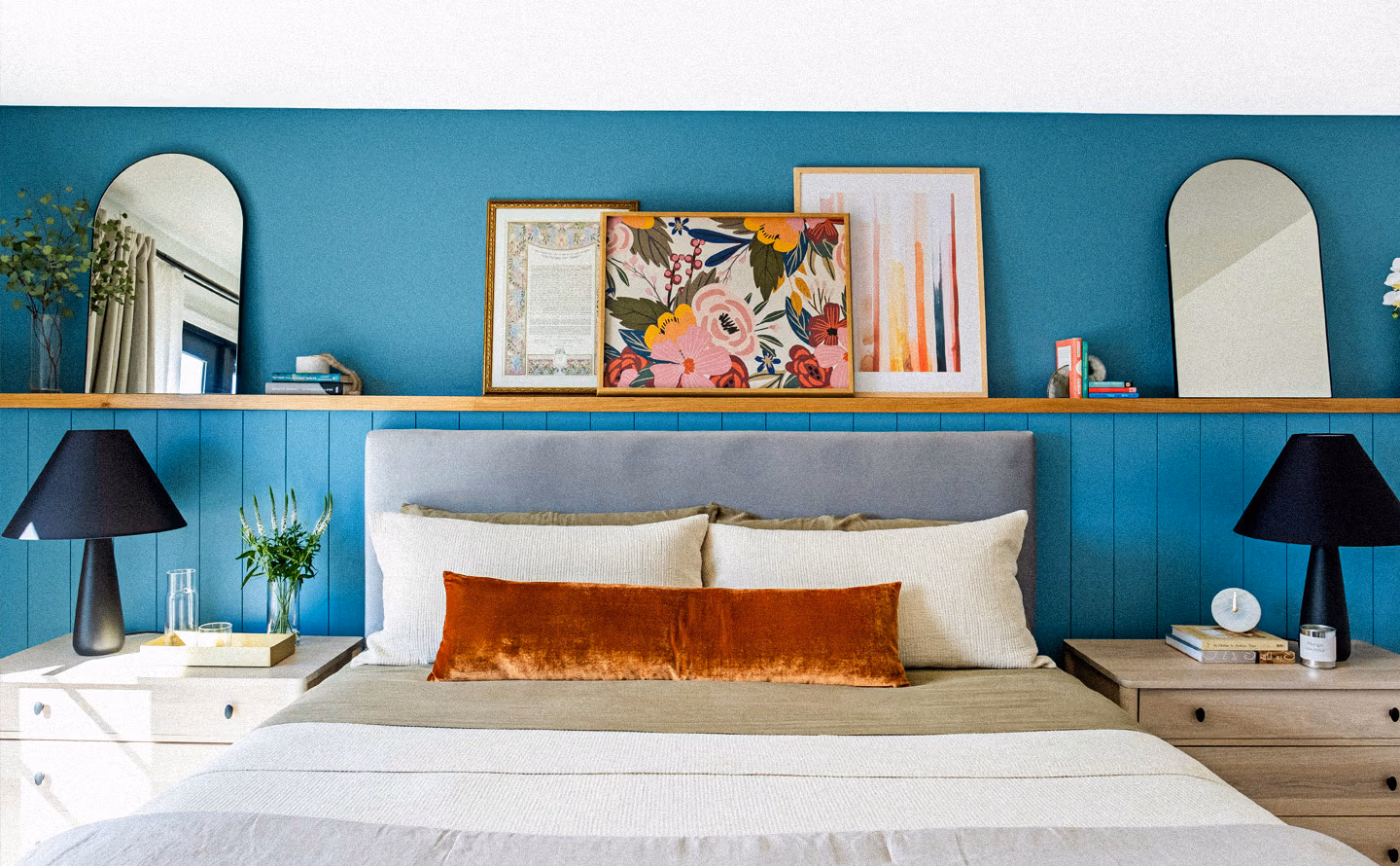 Chambre maximaliste avec mur et lambris bleu turquoise saturé, étagère en bois clair exposant œuvres d'art colorées et miroirs arrondis, lit aux linges beige crème et coussin velours rouille illustrant l'équilibre entre audace chromatique et respiration visuelle par matières naturelles terreuses Chambre maximaliste avec mur et lambris bleu turquoise saturé, étagère en bois clair exposant œuvres d'art colorées et miroirs arrondis, lit aux linges beige crème et coussin velours rouille illustrant l'équilibre entre audace chromatique et respiration visuelle par matières naturelles terreuses