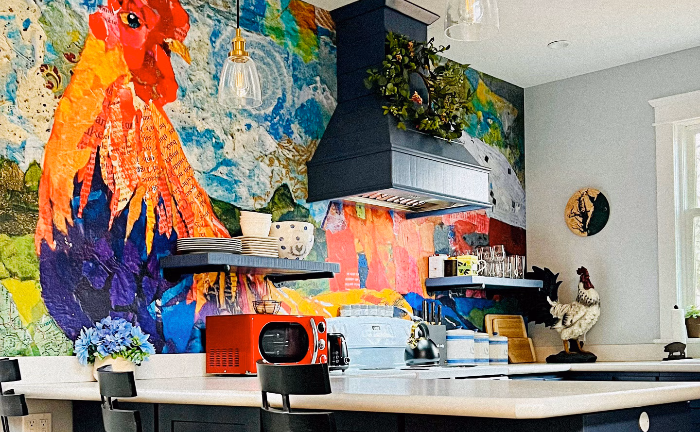 Cuisine contemporaine avec fresque murale panoramique peinte représentant coq exotique aux plumes rouges orangées jaunes violettes sur fond abstrait turquoise vert anis, étagères flottantes noires sous hotte graphite, plan de travail blanc avec micro-ondes rétro rouge vif, figurines animales décoratives, illustrant comment l'art mural monumental crée une présence visuelle permanente et transforme l'espace fonctionnel en galerie vivante. Cuisine contemporaine avec fresque murale panoramique peinte représentant coq exotique aux plumes rouges orangées jaunes violettes sur fond abstrait turquoise vert anis, étagères flottantes noires sous hotte graphite, plan de travail blanc avec micro-ondes rétro rouge vif, figurines animales décoratives, illustrant comment l'art mural monumental crée une présence visuelle permanente et transforme l'espace fonctionnel en galerie vivante.