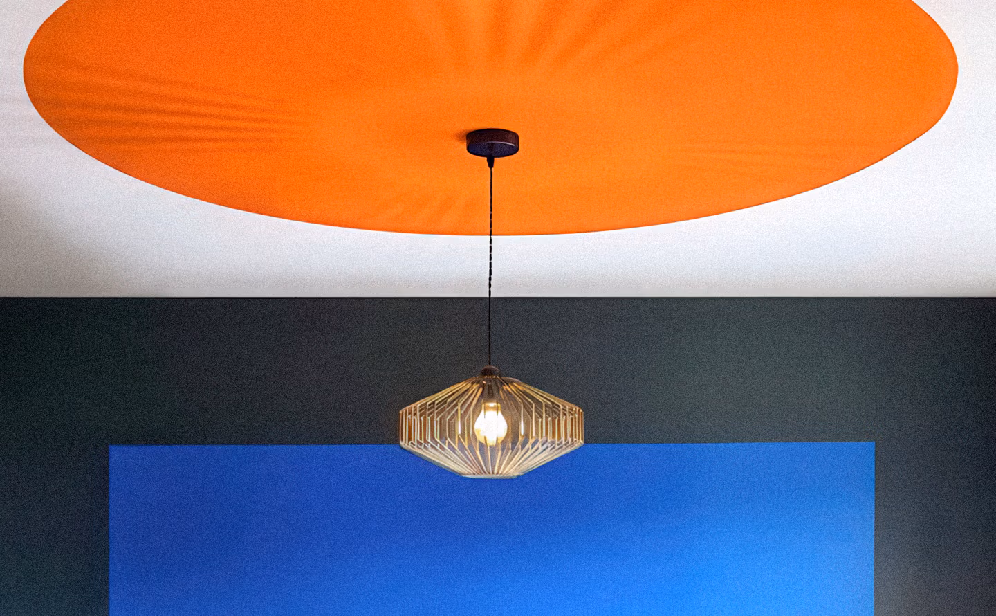 Plafond traité en color-blocking avec grande forme circulaire orange vif et murs tricolores en bandes horizontales blanc, anthracite et bleu cobalt, suspension géométrique en laiton filaire, illustrant le potentiel décoratif de la cinquième paroi transformée en manifeste chromatique. Plafond traité en color-blocking avec grande forme circulaire orange vif et murs tricolores en bandes horizontales blanc, anthracite et bleu cobalt, suspension géométrique en laiton filaire, illustrant le potentiel décoratif de la cinquième paroi transformée en manifeste chromatique.