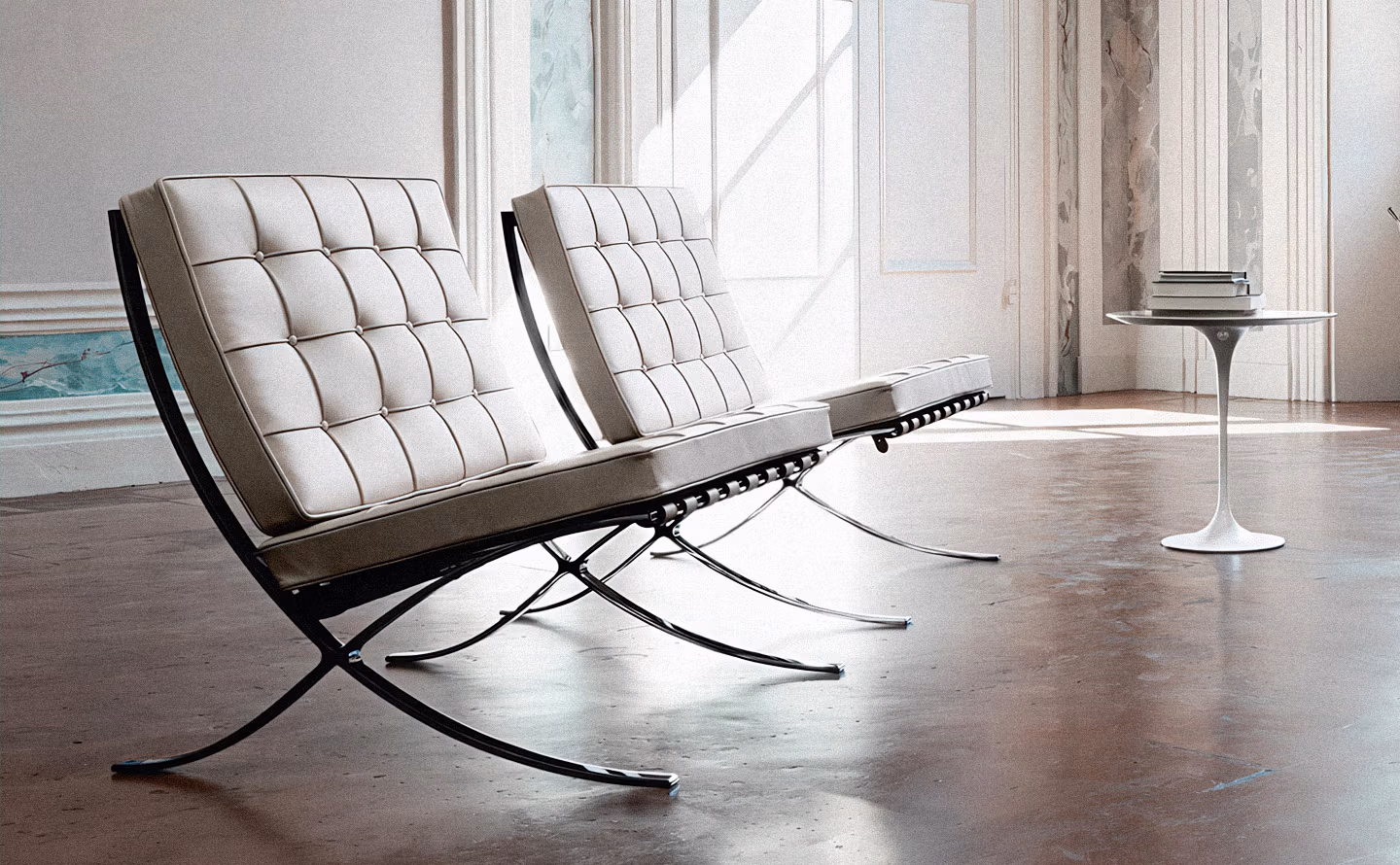 Paire de fauteuils Barcelona de Mies van der Rohe en cuir blanc capitonné sur structure chromée en X, associés à une table d'appoint Tulip de Saarinen, dans un intérieur lumineux aux murs clairs moulurés et sol en béton ciré reflétant la lumière naturelle