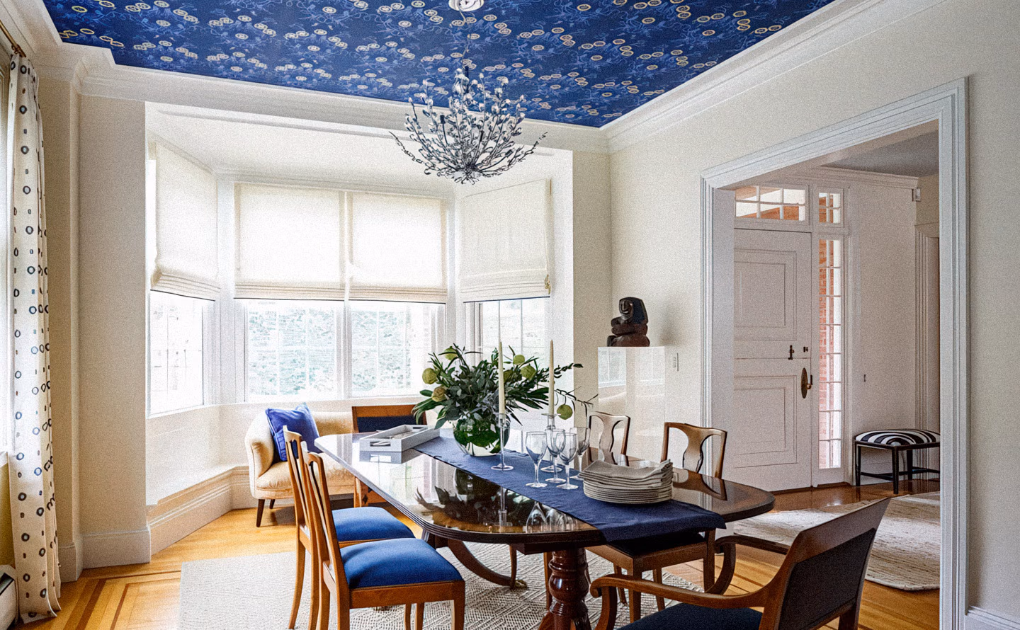 Salle à manger élégante avec plafond habillé de papier peint bleu cobalt profond à motifs floraux dorés décoratifs, moulures blanches encadrant la cinquième paroi, lustre cristal branche sculptural, table ovale bois foncé plateau verre avec chaises dépareillées velours bleu et bois, bow-window avec stores romains lin, porte blanche à imposte vitré, illustrant qu'un plafond traité comme toile vierge avec motifs audacieux transforme radicalement la perception des volumes et signale une sophistication décorative qui distingue les intérieurs véritablement réfléchis des aménagements conventionnels. Salle à manger élégante avec plafond habillé de papier peint bleu cobalt profond à motifs floraux dorés décoratifs, moulures blanches encadrant la cinquième paroi, lustre cristal branche sculptural, table ovale bois foncé plateau verre avec chaises dépareillées velours bleu et bois, bow-window avec stores romains lin, porte blanche à imposte vitré, illustrant qu'un plafond traité comme toile vierge avec motifs audacieux transforme radicalement la perception des volumes et signale une sophistication décorative qui distingue les intérieurs véritablement réfléchis des aménagements conventionnels.