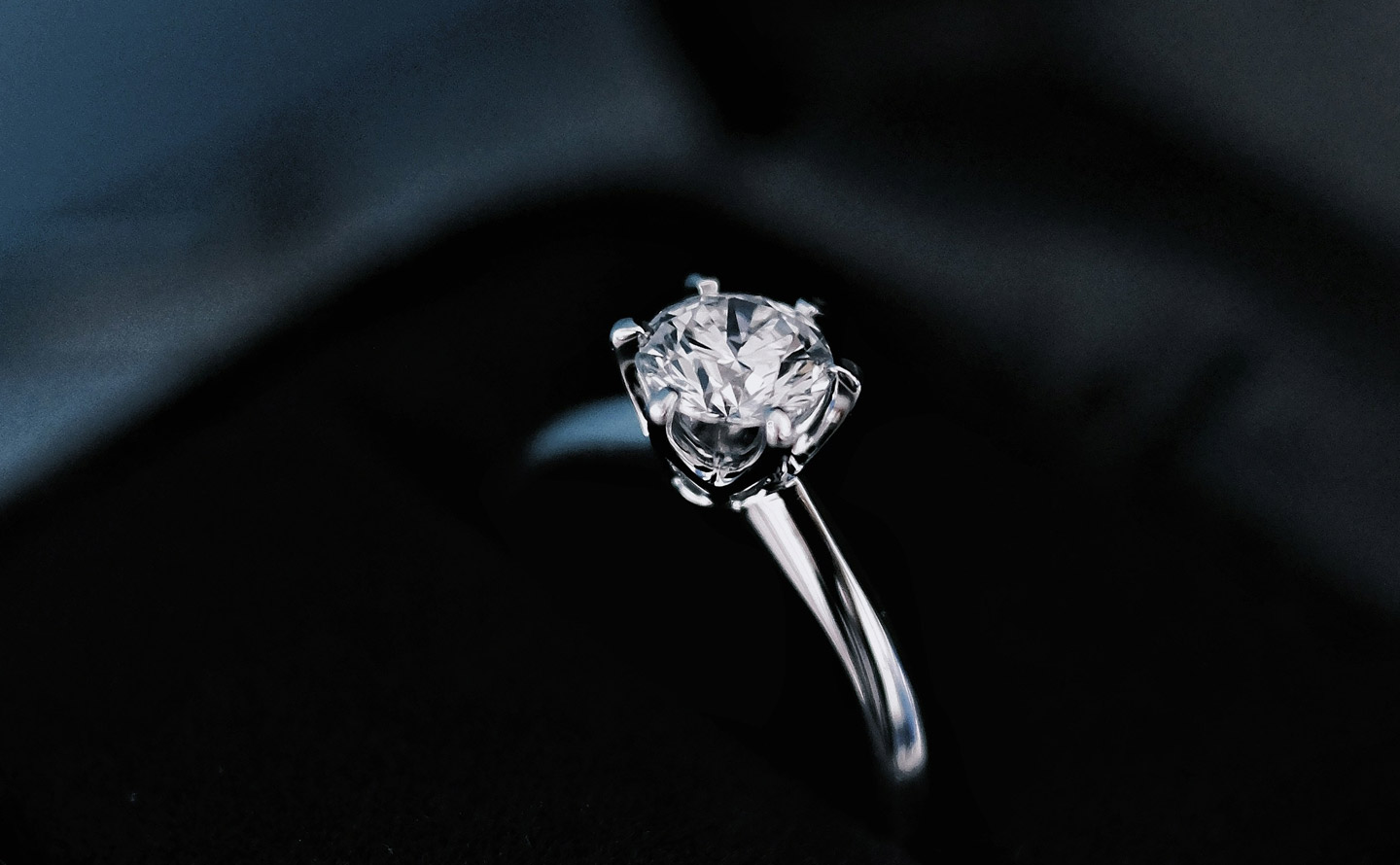 Bague de fiançailles solitaire en or blanc sertie d'un diamant rond brillant dans son écrin noir, symbole intemporel de l'engagement amoureux